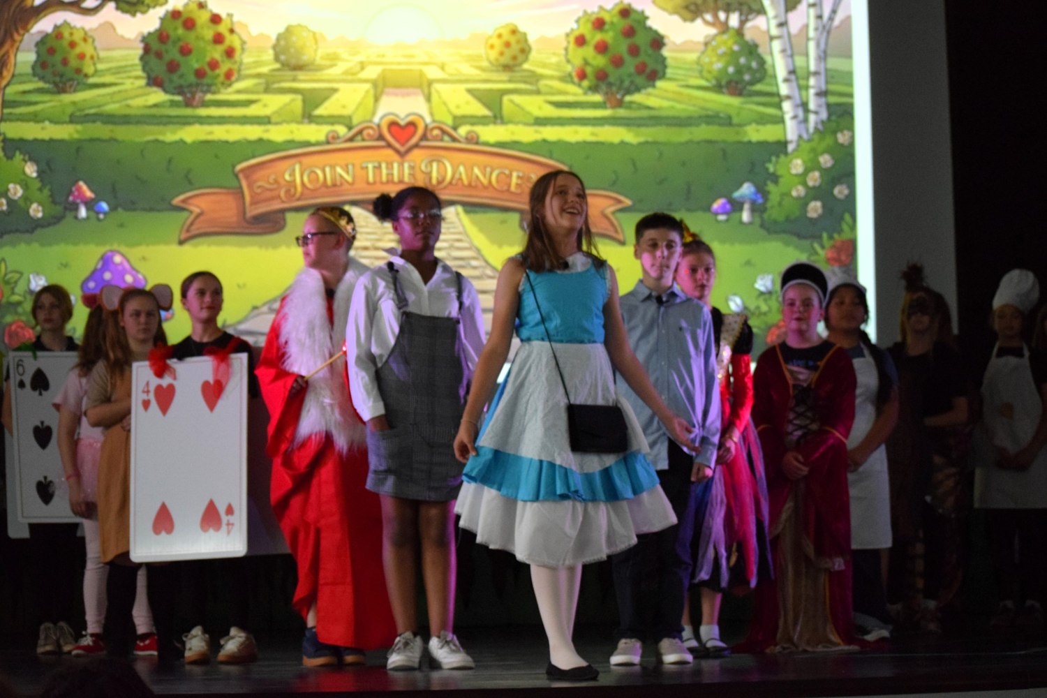 CCS Southport students on stage in costume during a performance of Wonderland.