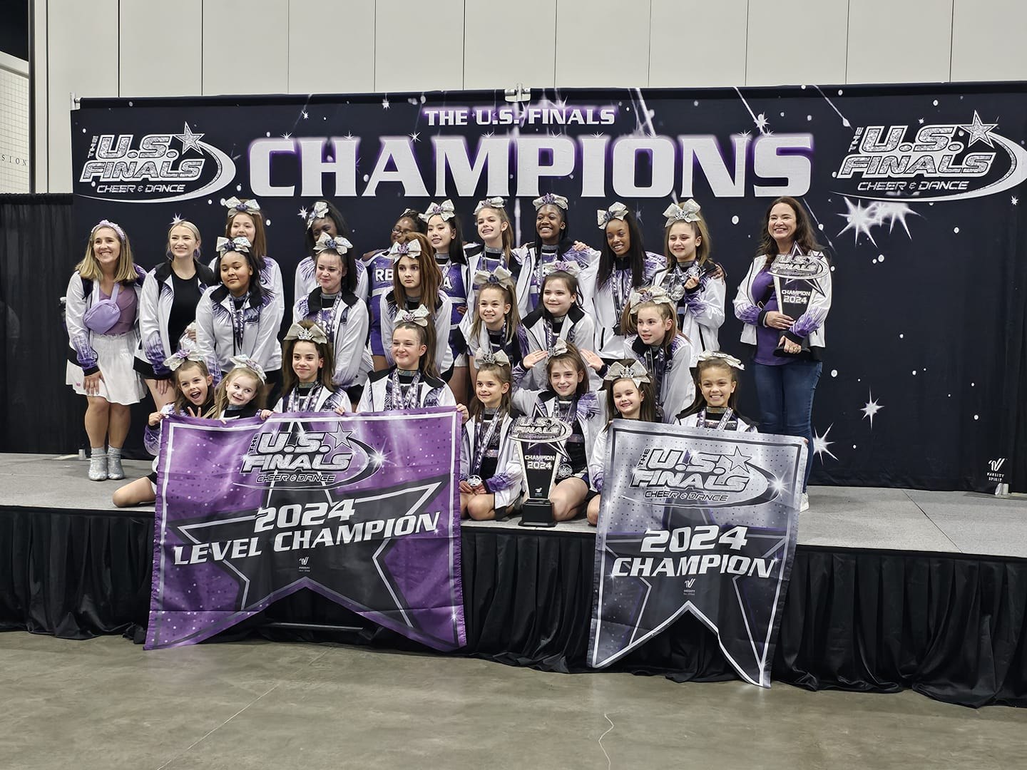 CCS-America cheerleaders with their 2024 U.S. Finals championship banners.